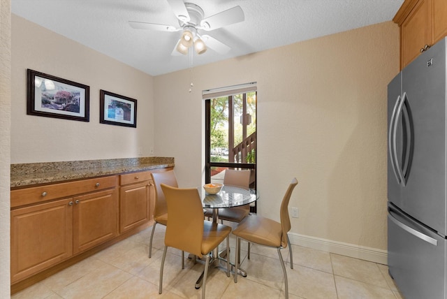 tiled dining room featuring ceiling fan and a textured ceiling