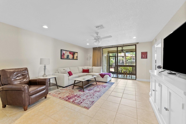 tiled living room with ceiling fan and a textured ceiling