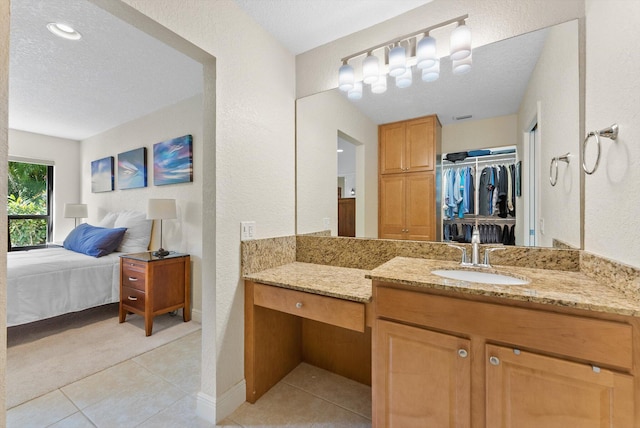 bathroom featuring tile patterned flooring, vanity, and a textured ceiling