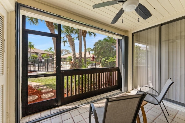 sunroom featuring a healthy amount of sunlight, wooden ceiling, and ceiling fan