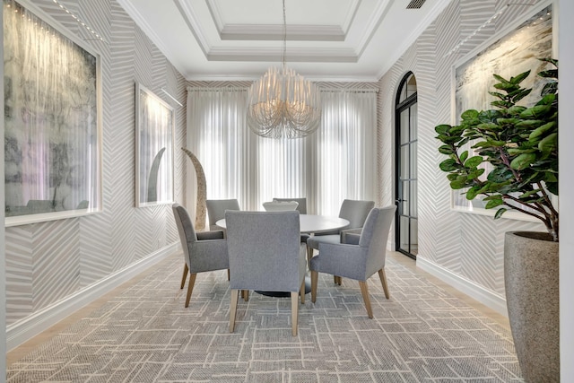 dining area featuring an inviting chandelier, a tray ceiling, and crown molding