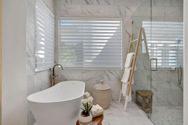 bathroom featuring a wealth of natural light and independent shower and bath