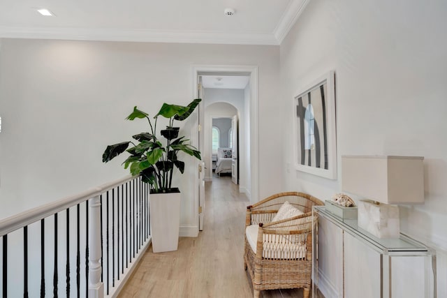 hallway featuring ornamental molding and light hardwood / wood-style floors