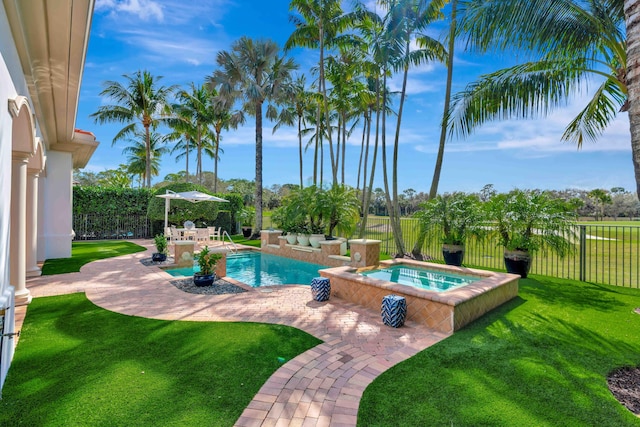 view of swimming pool featuring an in ground hot tub, a yard, and a patio area