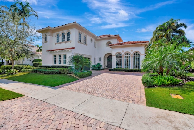 mediterranean / spanish-style home with a front yard