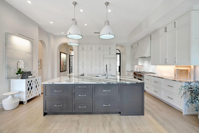 kitchen featuring gray cabinets, white cabinetry, custom exhaust hood, hanging light fixtures, and a large island