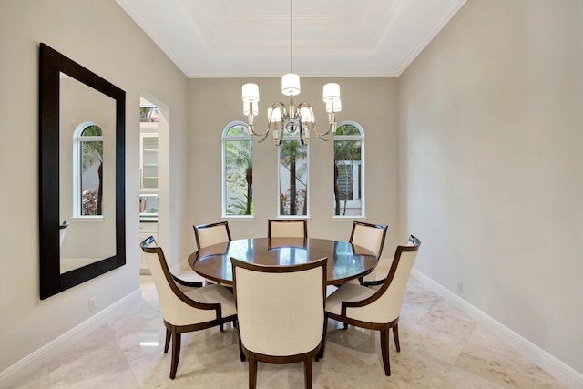 dining room with ornamental molding, a tray ceiling, and a chandelier