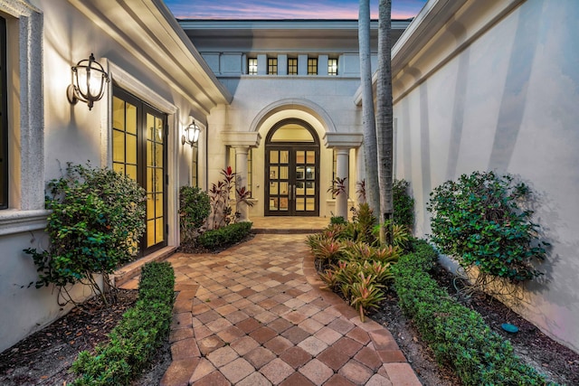 exterior entry at dusk featuring french doors