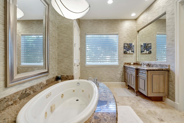 bathroom featuring vanity and tiled bath