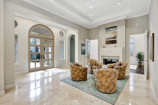 living room featuring ornamental molding, french doors, a raised ceiling, and a high ceiling