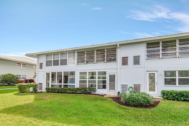 rear view of property with a lawn