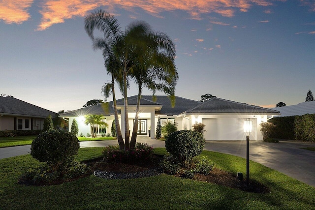 ranch-style home with a garage and a yard