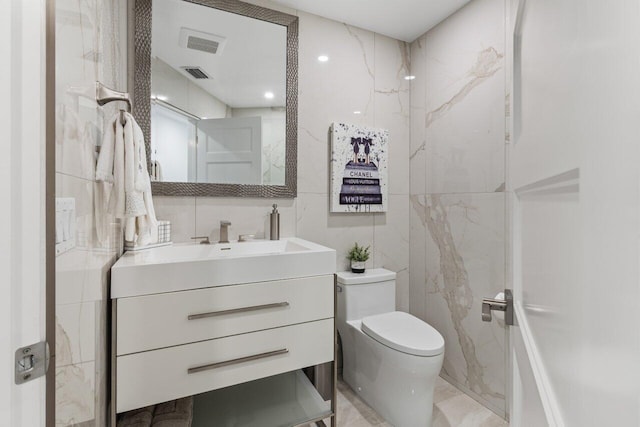 11955 N Lake Dr, Boynton Beach, FL 33436 - bathroom with vanity, toilet, and tile walls