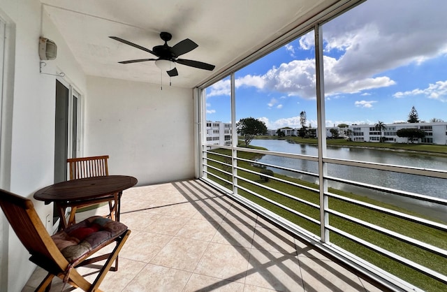 sunroom / solarium featuring ceiling fan and a water view