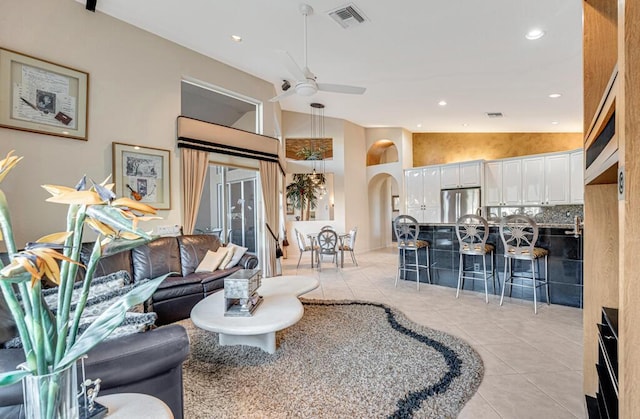 living room featuring high vaulted ceiling, light tile patterned floors, and ceiling fan