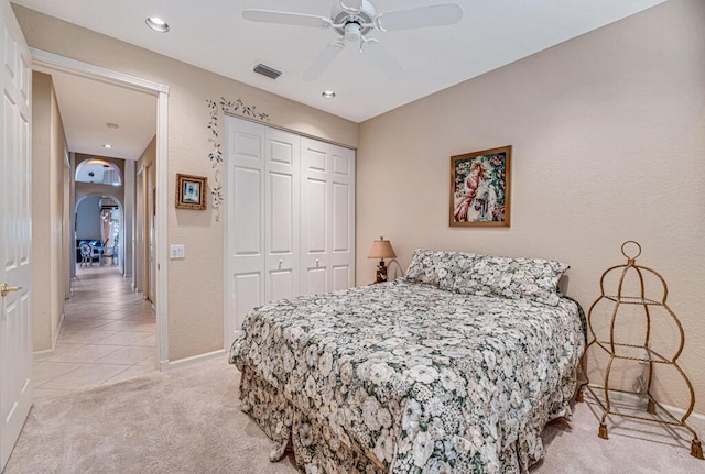 carpeted bedroom featuring ceiling fan and a closet