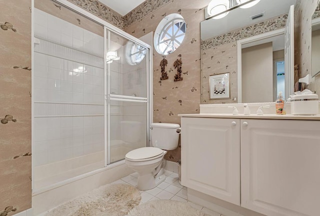 bathroom featuring vanity, toilet, tile patterned floors, and a shower with shower door