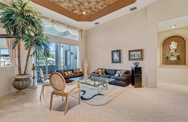 living room with light tile patterned floors, a wealth of natural light, ornamental molding, and a raised ceiling