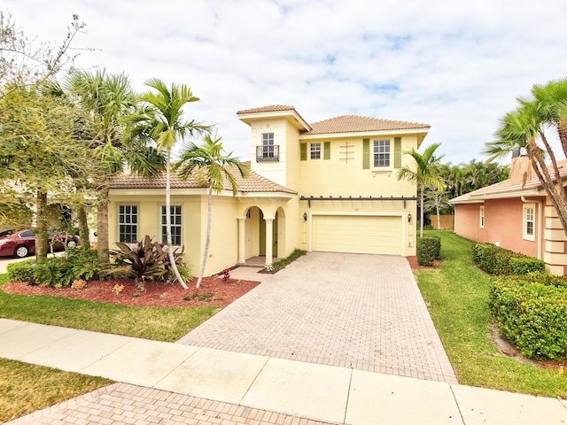 mediterranean / spanish home with a garage and a front lawn