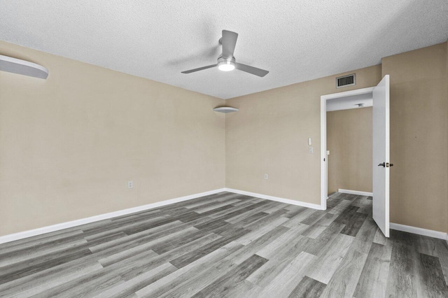 unfurnished room with ceiling fan, hardwood / wood-style floors, and a textured ceiling