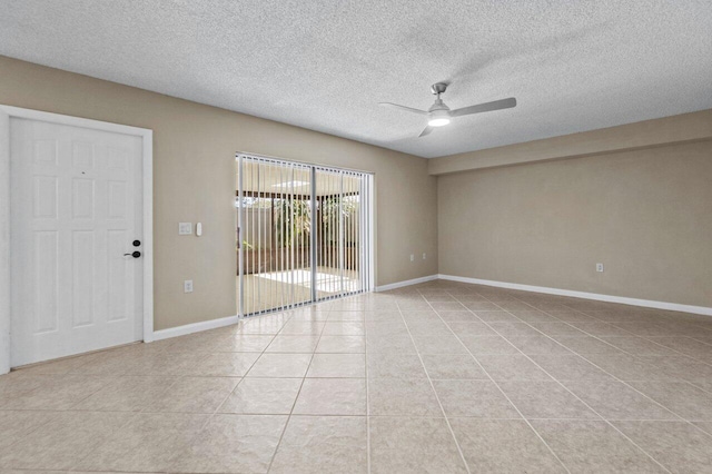 tiled empty room featuring ceiling fan and a textured ceiling