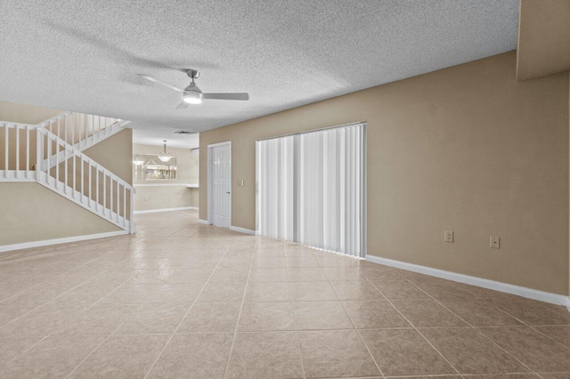 unfurnished living room with light tile patterned floors, a textured ceiling, and ceiling fan