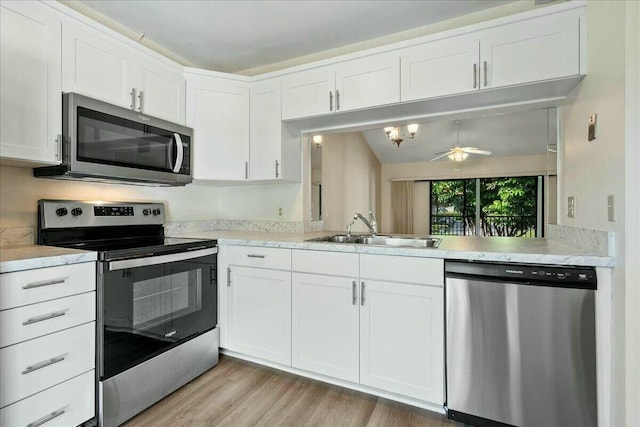 kitchen with sink, light hardwood / wood-style flooring, appliances with stainless steel finishes, ceiling fan, and white cabinets