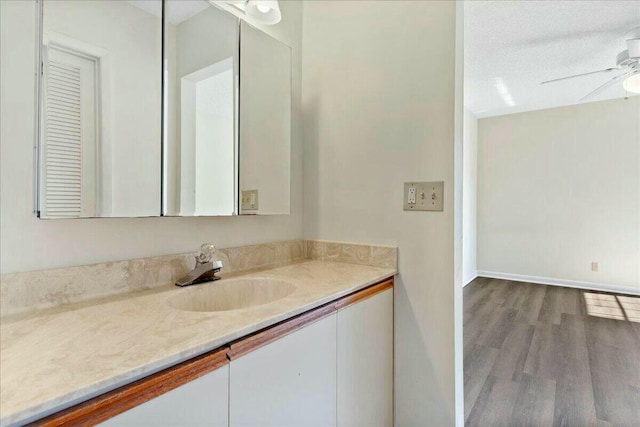 bathroom with ceiling fan, vanity, and wood-type flooring