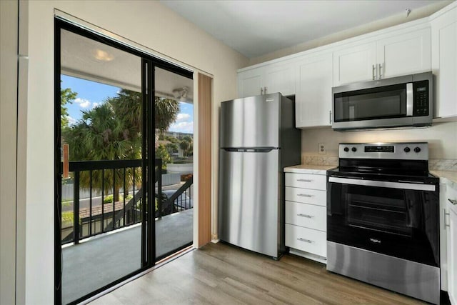 kitchen with stainless steel appliances, light wood-type flooring, and white cabinets