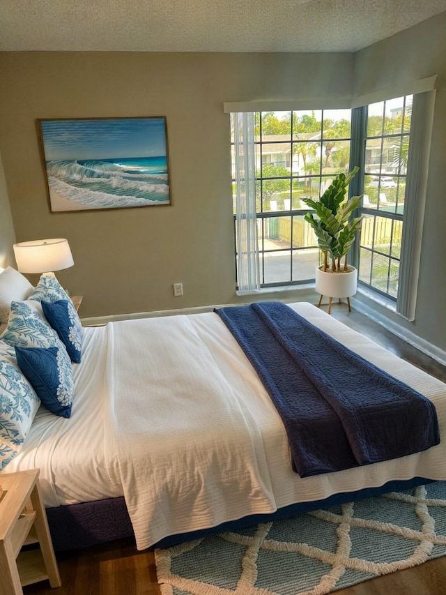 bedroom featuring hardwood / wood-style flooring and a textured ceiling