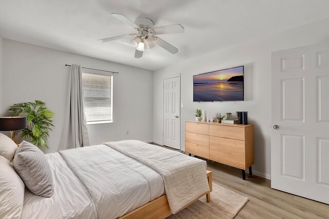 bedroom featuring ceiling fan, light wood finished floors, and baseboards