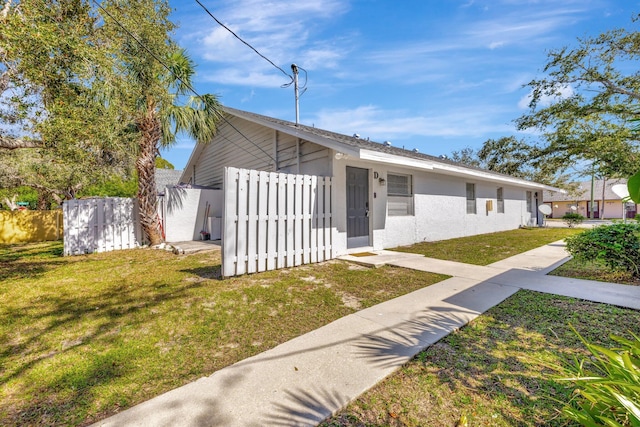 bungalow featuring stucco siding, fence, and a front yard