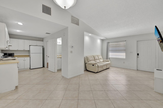 interior space featuring visible vents, a textured ceiling, baseboards, and light tile patterned flooring