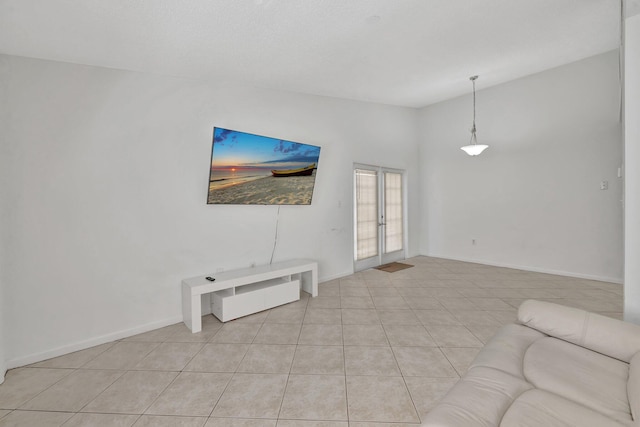 unfurnished living room featuring lofted ceiling, light tile patterned floors, baseboards, and french doors