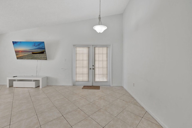 foyer featuring lofted ceiling, french doors, light tile patterned floors, and baseboards