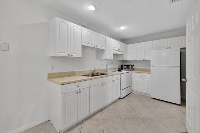 kitchen with light tile patterned floors, light countertops, white cabinets, a sink, and white appliances