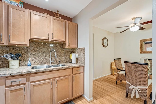 kitchen with light hardwood / wood-style floors, sink, decorative backsplash, and light brown cabinets