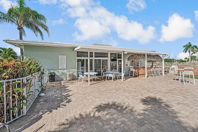 rear view of property featuring a bar and a patio area