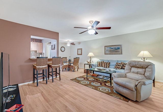 living room with ceiling fan and light wood-type flooring