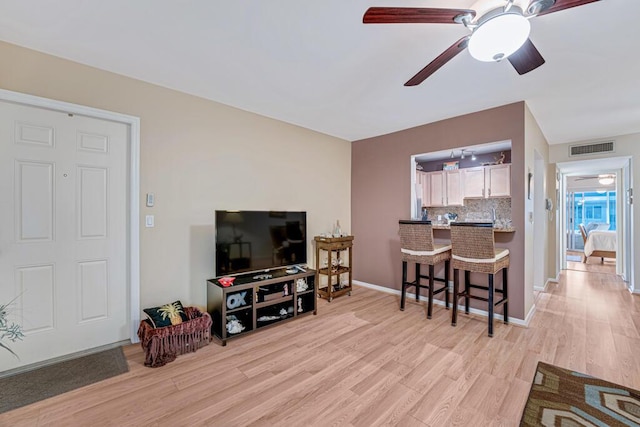 living room featuring light hardwood / wood-style flooring and ceiling fan