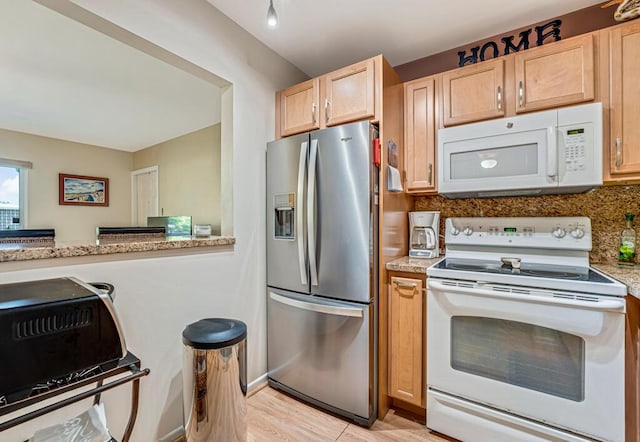 kitchen with tasteful backsplash, white appliances, light stone counters, light brown cabinets, and light wood-type flooring