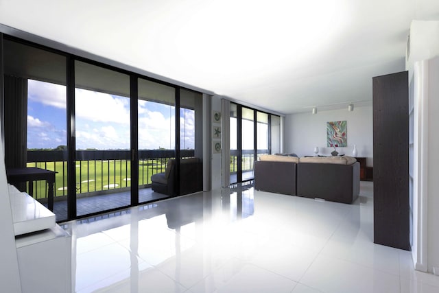 living room featuring expansive windows and light tile patterned flooring