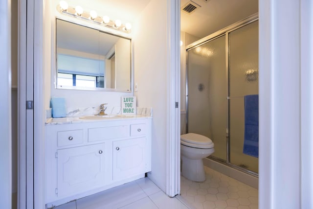 bathroom featuring tile patterned floors, vanity, toilet, and a shower with door