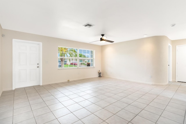spare room with light tile patterned floors, baseboards, visible vents, and a ceiling fan