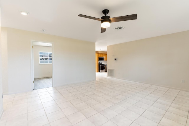 unfurnished room featuring a ceiling fan, visible vents, baseboards, and light tile patterned floors