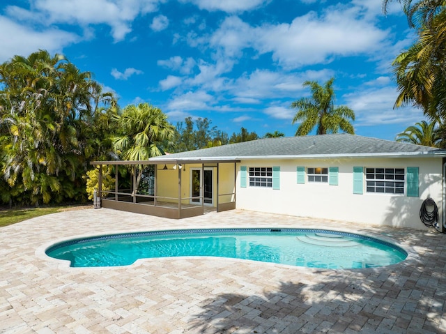 outdoor pool featuring a patio and a sunroom