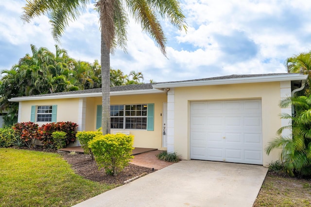single story home with a garage, driveway, and stucco siding