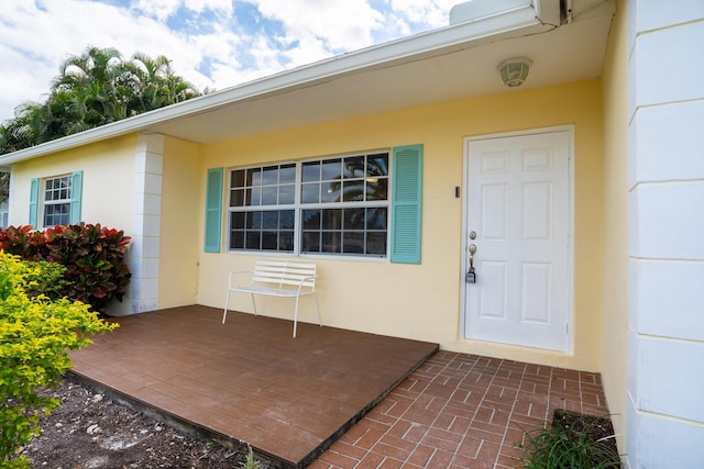 property entrance featuring a deck and stucco siding