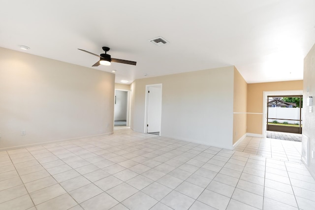 spare room with ceiling fan, light tile patterned flooring, visible vents, and baseboards
