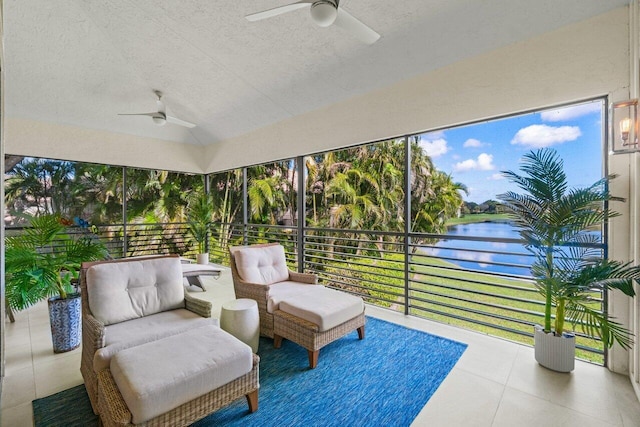 sunroom / solarium with a water view, lofted ceiling, and ceiling fan